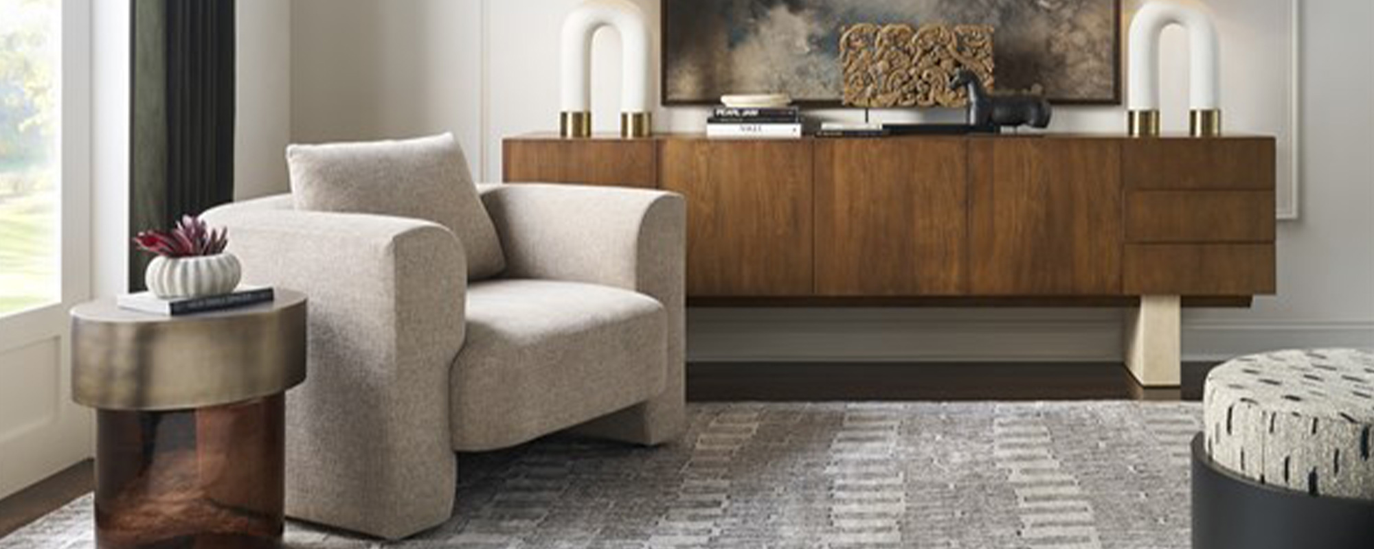 A large solid walnut dining table with a distinctive sculptural base and a smooth planked top is set for a gathering, exemplifying the blend of artistry and function in high-end casegoods with a rustic-modern Montana flair by Verellen.