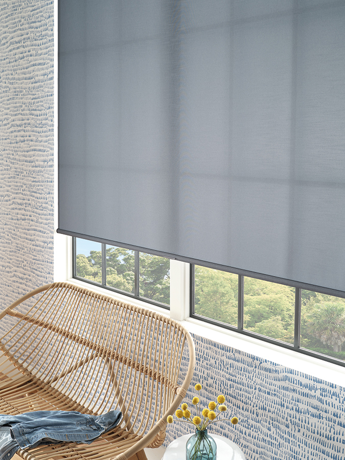 Blue-gray roller shades filtering soft daylight in a bright living room, part of the modern shades collection in Bozeman.