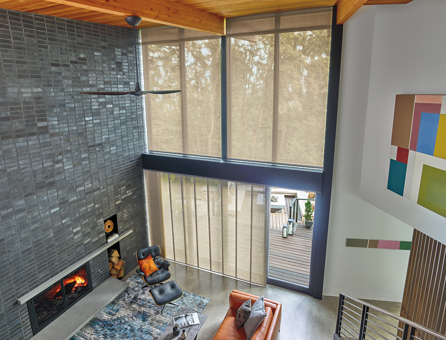 Neutral-toned screen shades over expansive sliding glass doors in a modern dining area, featuring custom window shades in Bozeman.