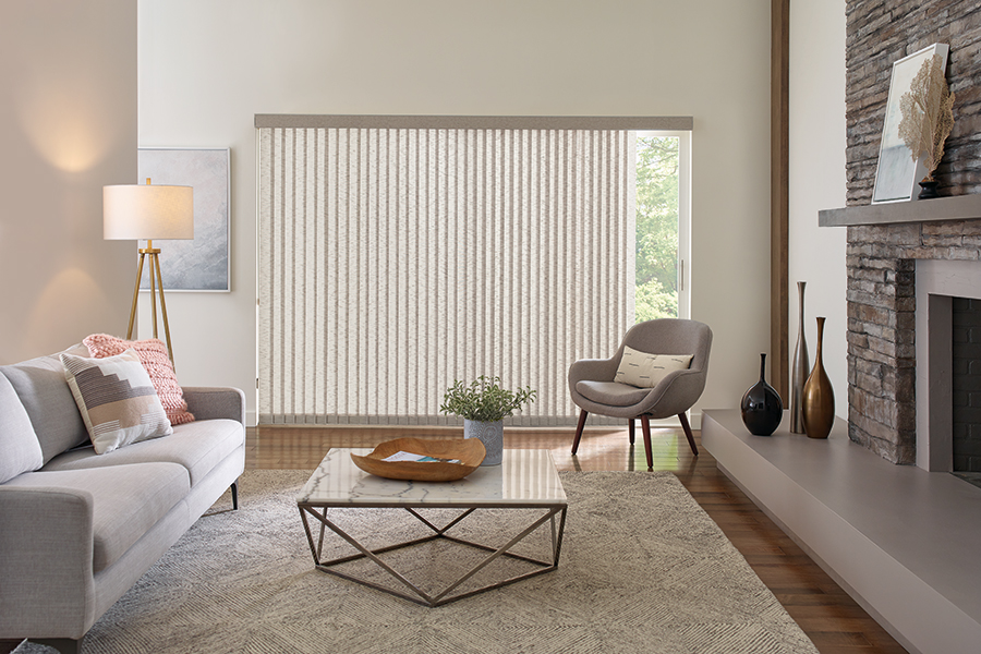Neutral-toned Somner vertical blinds frame a wide window in this Bozeman living room, balancing privacy with flexible light diffusion.