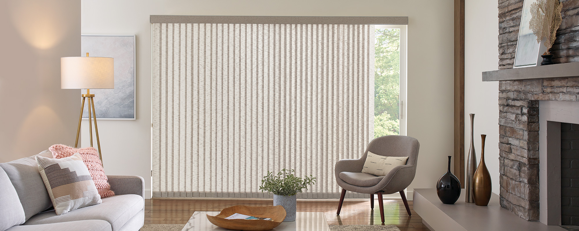 Neutral-toned Somner vertical blinds frame a wide window in this Bozeman living room, balancing privacy with flexible light diffusion.